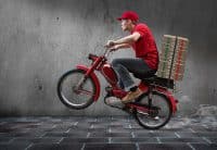 Mann auf einem Zweirad liefert Pizzen aus