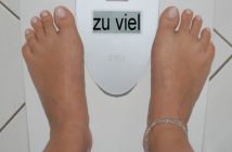 Mehrheit der Männer ist zu dick: 13. DGE-Ernährungsbericht Füße auf einer Waage, die "zu viel" anzeigt