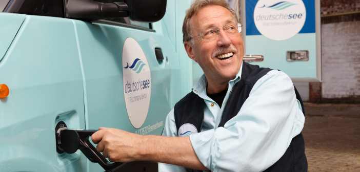Ein Deutsche-See-Mitarbeiter lädt den neuen E-Lieferwagen mit Strom auf.