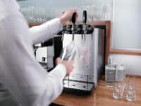 Die Culligan Aquabar steht auf einer Theke und wird von einer Person in einem hellen Hemd bedient.
